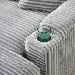 Grey corduroy single sofa with one pillow, two throw pillows, a footstool and two storage Spaces.